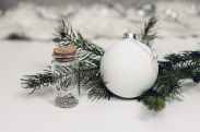 selective focus photography of white christmas bauble beside bottle with cork lid